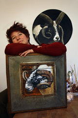 Die Künstlerin Heidi Theissen mit Gemälden von Schafen.