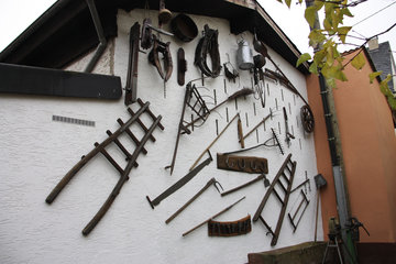 Alte Werkzeuge an einer Hauswand in Kordel, Südeifel