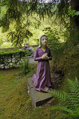 Betende Figur bei einer Lourdesgrotte nördlich von Ouren