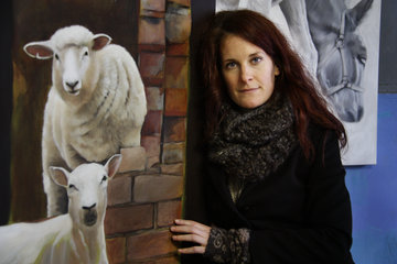 Die Künstlerin Katrin Plitzner mit Gemälden von Schafen und Eseln