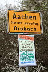 Ortsschild von Orsbach mit Plakat