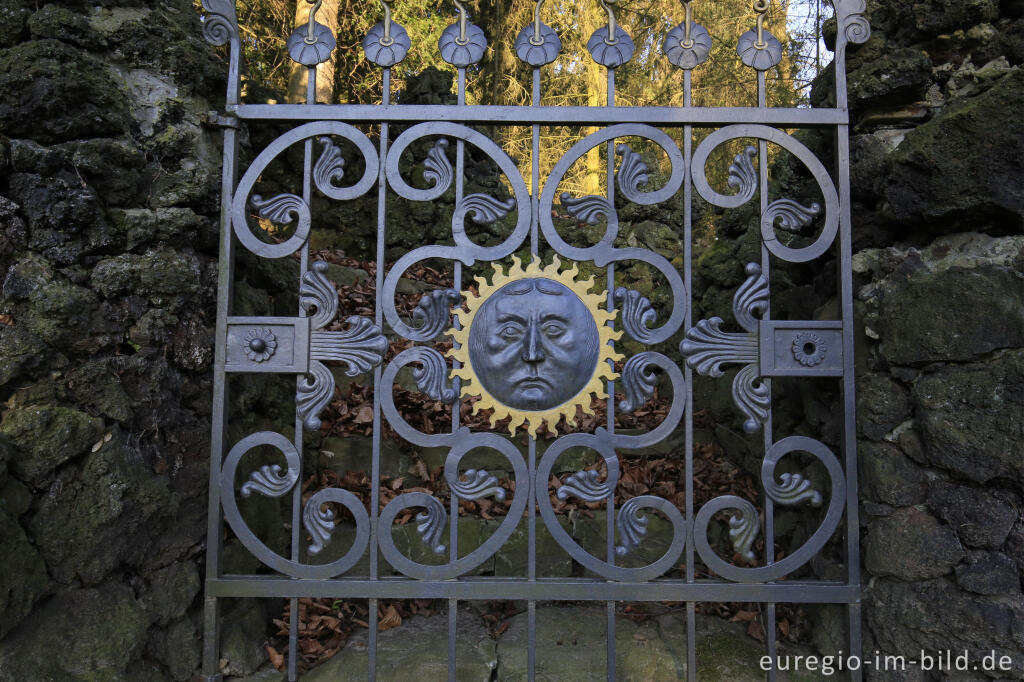 Detailansicht von Schmiedeeisernes Gatter mit ernst blickender Sonne, Kalvarienberg, Moresnet-Chapelle